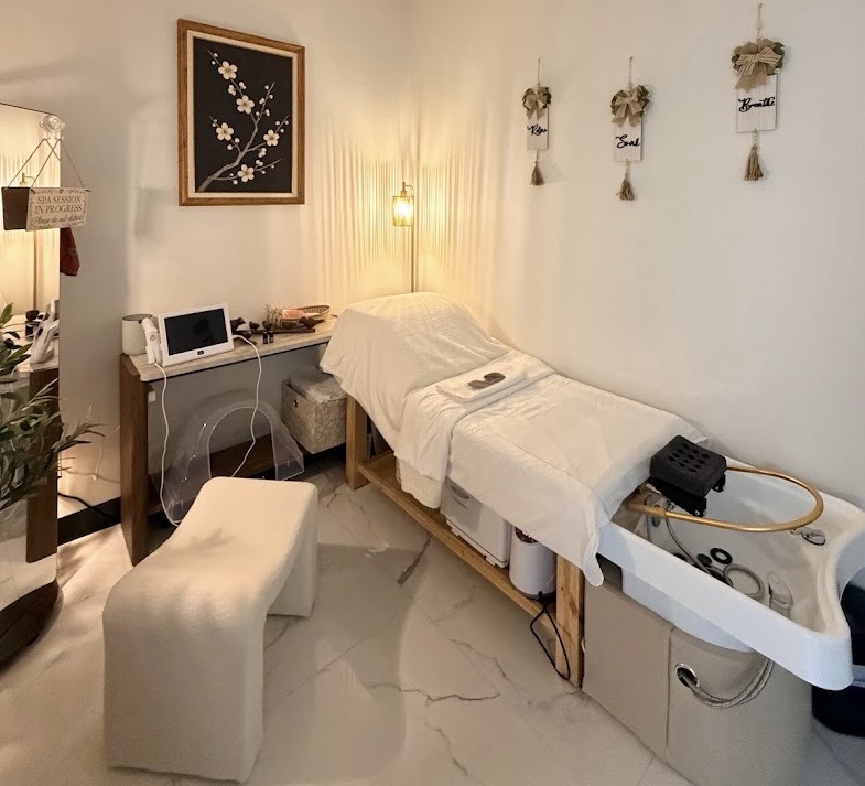 GlowMi private treatment studio with marble floors, cherry blossom art, and warm lamp